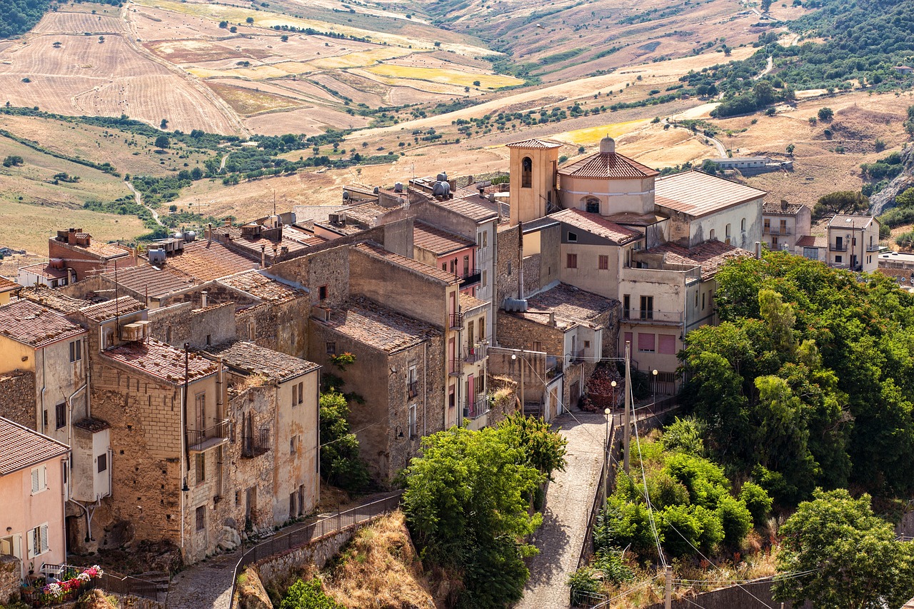Vista panoramica del suggestivo borgo lucano, con case storiche e paesaggio collinare.