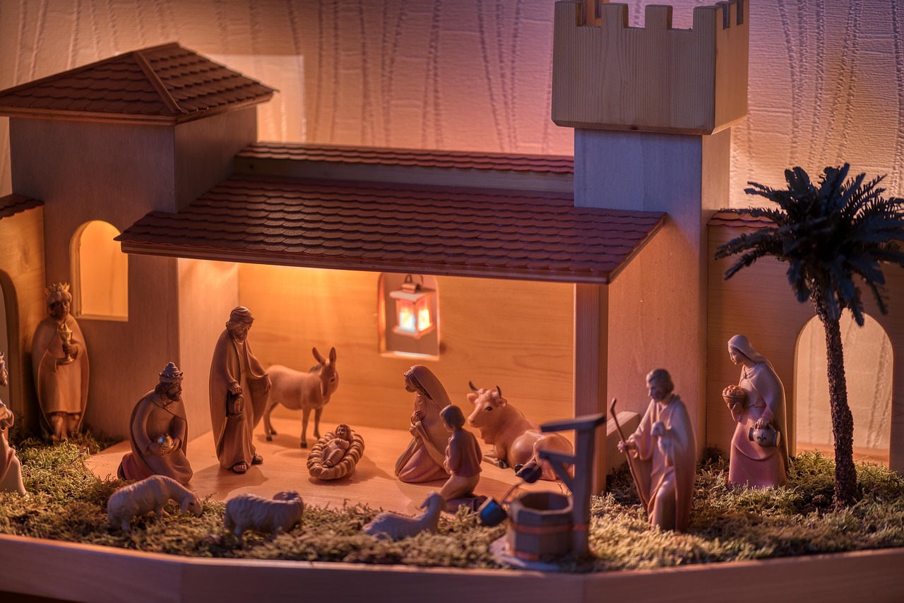 Borgo alpino incantevole, con case in legno e neve, che ricorda un presepe natalizio.