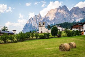 Vista panoramica del borgo nelle Dolomiti, circondato da montagne maestose e natura incontaminata.